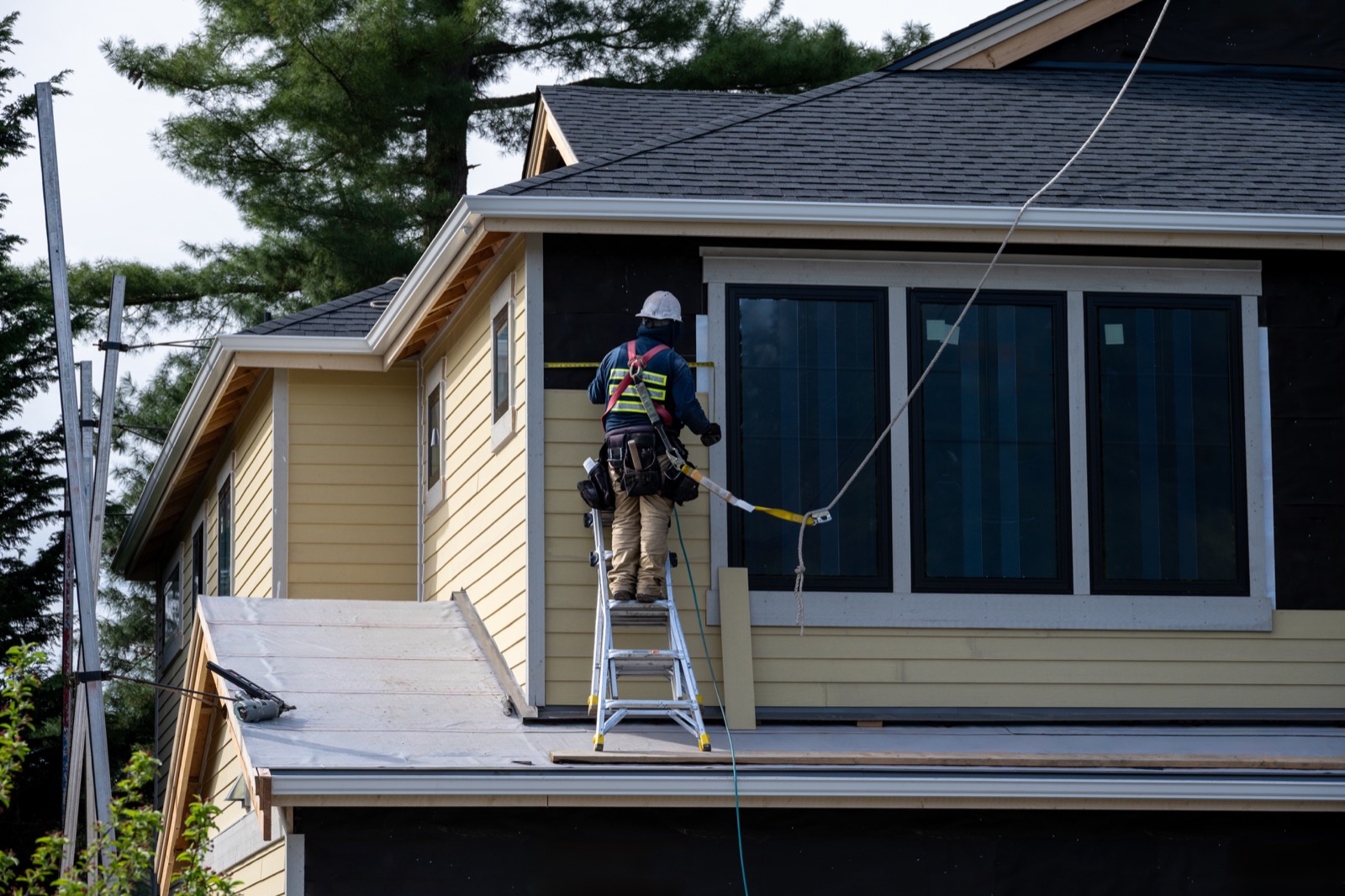 Technician performing roof and exterior measurement